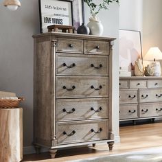 a dresser with drawers and pictures on top of it in a room next to a lamp