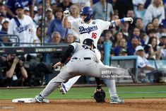 baseball player sliding into base during game with crowd watching from bleachers in background