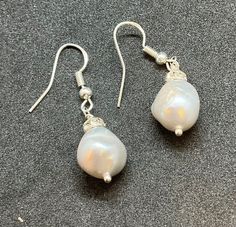 This gorgeous pair of drop earrings have been handmade using vintage fresh water pearl baroque pearls with Czech spacers onto new silver wires. The width of the pearl approx is 1.3 cm and the drop from the wire is 2.5 cm .  Come unworn in a gift box, a great gift or a treat for yourself. Silver Baroque Pearl Dangle Earrings, Silver Baroque Pearl Earrings In Pear Shape, Handmade Silver Pear-shaped Pearl Earrings, Handmade Silver Pearl Earrings In Pear Shape, Silver Pear-shaped Baroque Pearl Earrings, Silver Baroque Pearl Drop Earrings, Pearl Baroque, Fresh Water Pearl, Pearl Drop Earrings