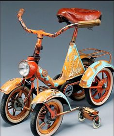 an old fashioned tricycle is painted orange and blue