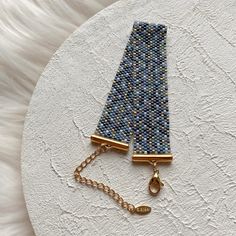 a pair of blue and gold bracelets on a white surface