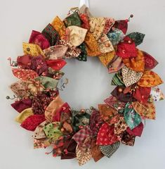 a wreath made out of fabric is hanging on the wall