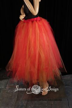 a mannequin dressed in an orange and black tutu skirt with red trim