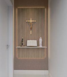 a wall with a crucifix, book and vase on it next to a shelf