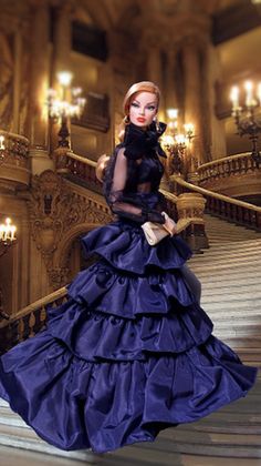 a barbie doll is standing on the stairs in a blue dress with black lace and pearls