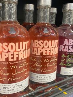 three bottles of absolut apefruit are on display in a grocery store