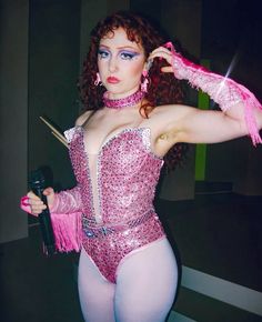 a woman dressed in pink is posing for the camera