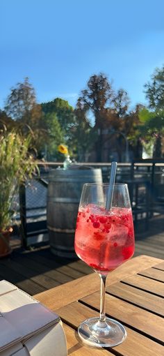 a glass filled with liquid sitting on top of a wooden table