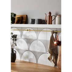 a kitchen counter with pots and pans on it, next to a pot rack