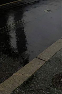 a fire hydrant sitting on the side of a wet street