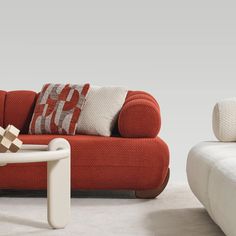 a red and white couch sitting next to each other on top of a carpeted floor