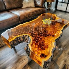 a coffee table made out of honeycombs on top of a wooden floor next to a leather couch