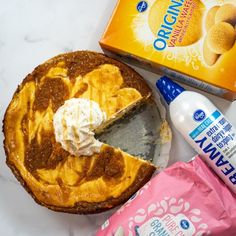 a pie with whipped cream on top next to an ice cream box