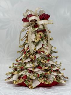 a small christmas tree made out of fabric and ribbon with bows on it's top