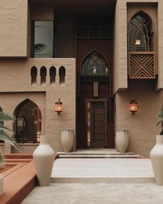 a large building with two tall white vases sitting in front of it's entrance