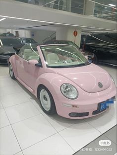 a pink car is parked in a showroom