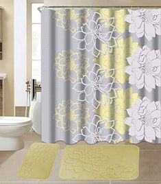 a bathroom with yellow and gray shower curtains, rugs and toilet paper on the floor