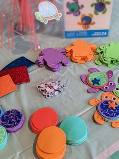 the table is covered with colorful plastic buttons and magnets for kids to play with