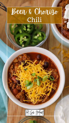 two bowls filled with chili and cheese on top of a wooden table