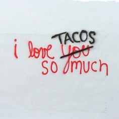 graffiti written on the side of a building says tacos i love you so much