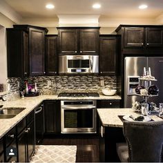 a kitchen with dark wood cabinets and stainless steel appliances