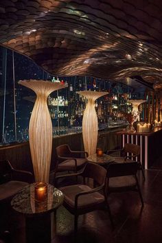 two tall vases sitting next to each other on top of a wooden table in front of a bar