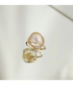 Live your vintage inspired dreams with our pearl and diamond ring. With the pearl bead in the middle and CZ Diamonds surrounding this is the perfect romantic gift for an engagement ring.• Material: High Quality 14K Gold Plated• Finish: 14K Gold Luxury Pearl Ring With Rose Cut Diamonds For Anniversary, Luxury Pearl Ring With Diamond Accents For Promise, Elegant Rose Gold Pearl Ring, Elegant Rose Gold Pearl Ring With Diamond, Pearl Ring With Diamond Accents, Luxury Oval Pearl Ring, Luxury Pearl White Pearl Ring For Wedding, Elegant Open Halo Ring For Anniversary, Elegant Open Pearl Ring For Anniversary