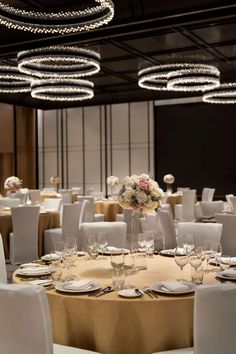 a banquet room with round tables and white chairs