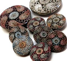 six buttons with different designs on them sitting next to each other in the shape of circles