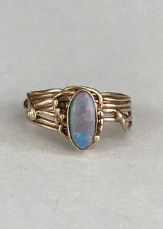 The beautiful oval shaped opal is bezel set and framed by delicate gold lines and little gold dots. The band continues with the swirling lines that come together to form a smooth band. This ring is a size 6 1/2. It is in beautiful vintage condition. Please see all photos for details, as well as, condition.Thank you for looking!I'm happy to offer layaway on certain items. Please ask for details. Adjustable Oval Opal Ring In 14k Gold, Adjustable 14k Gold Oval Opal Ring, Adjustable 14k Gold Opal Ring, Filigree Diamond Ring, Opal Stone Ring, Heart Shaped Frame, Opal Band, Vintage Sterling Silver Rings, Gold Dots