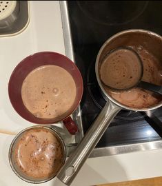 two pots on the stove with hot chocolate in them