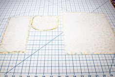 two square pieces of fabric on a cutting board with a ruler and measuring tape next to them