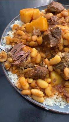 a plate full of beans, meat and rice