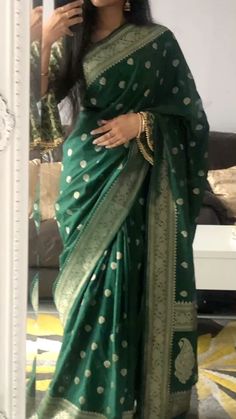 a woman in a green and gold sari