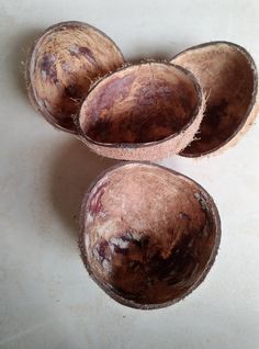 three coconuts that have been peeled and are sitting on a white surface with some brown spots