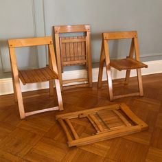 three wooden chairs sitting on top of a hard wood floor