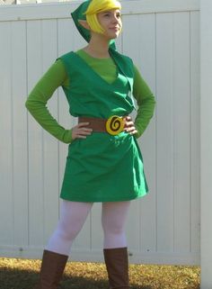 a woman dressed in green and yellow stands with her hands on her hips while wearing brown boots