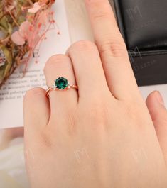 a woman's hand with a green ring on it