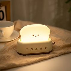 a toast light sitting on top of a table next to a cup and saucer