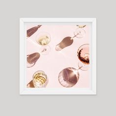 several glasses of wine are arranged in a circle on a pink tablecloth with shadows