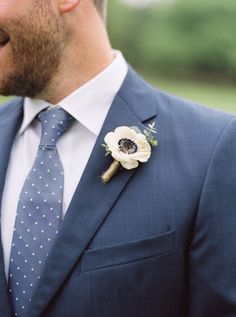 a man in a suit and tie with a boutonniere on his lapel