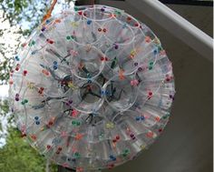 a clear umbrella with colorful beads hanging from it's side in front of trees