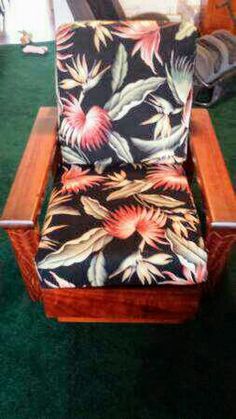 a wooden rocking chair with floral fabric on it