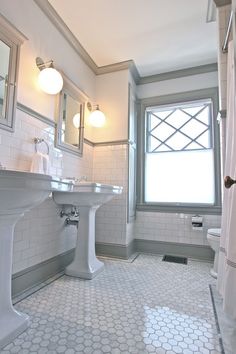 a bathroom with two sinks, a toilet and a bathtub next to a window