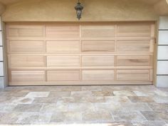 a wooden garage door is open on the side of a house with tile flooring