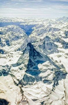 an aerial view of snow covered mountains and valleys