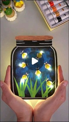 someone is holding up a jar with lights in it