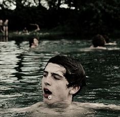 some people swimming in the water and one is sticking his tongue out