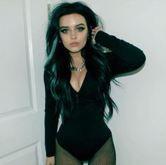 a woman with long black hair wearing fishnet stockings