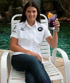 a woman sitting on a white chair holding a drink